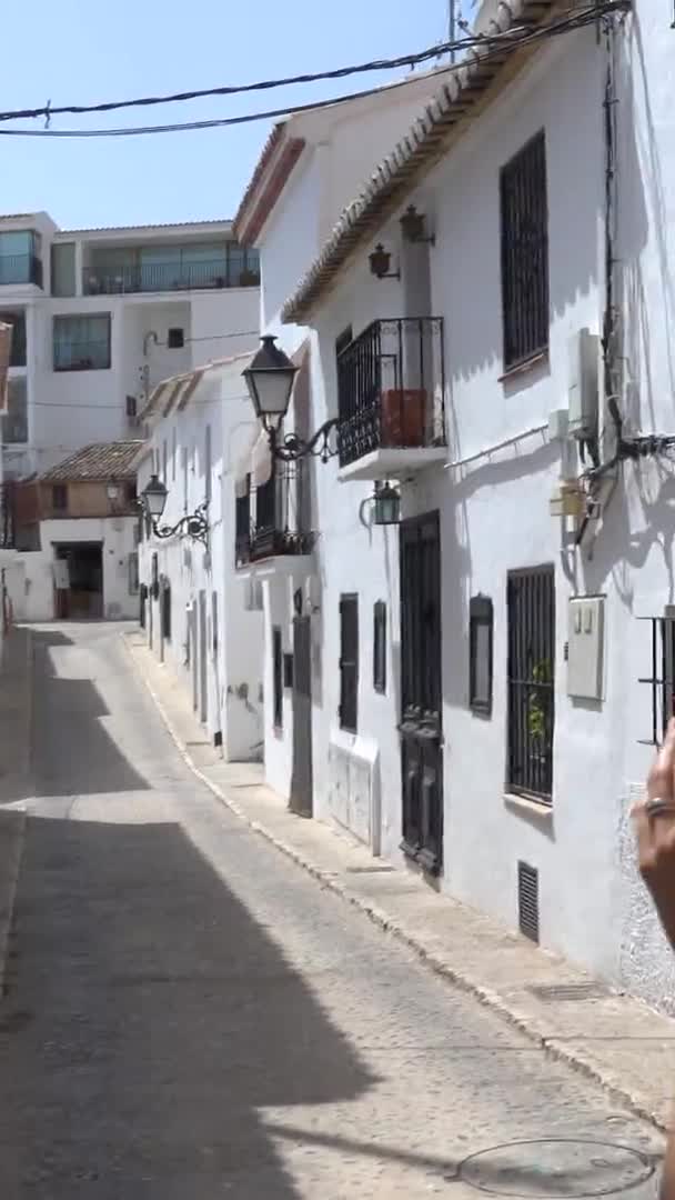 Altea, Alicante, İspanya 'nın beyaz köyünde fotoğraf çeken turist kıvırcık esmerin dikey videosu. — Stok video