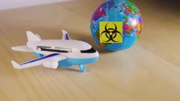 Avión de juguete junto a un globo con el símbolo de peligro biológico — Vídeo de stock
