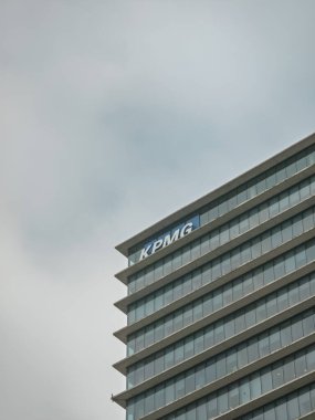 Barcelona, Spain. September 12, 2025, Modern glass facade of KPMG headquarters in Barcelona, Spain, standing tall against a gray, overcast sky