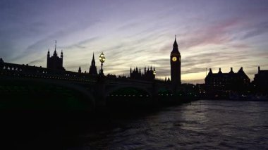 Westminster and Big Ben silhouette at sunset over Thames river