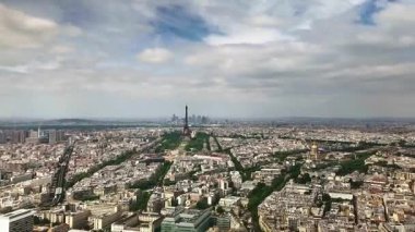 Aerial timelapse showing the iconic cityscape of Paris, France, with the Eiffel Tower and the business district of La Defense as clouds and shadows move quickly across the urban landscape