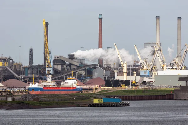 Steel factory Dutch harbor IJmuiden with cargo carrier in front, — Stock Photo, Image