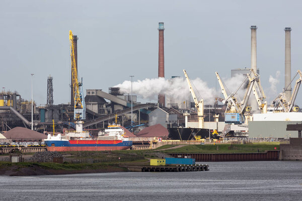 Steel factory Dutch harbor IJmuiden with cargo carrier in front,