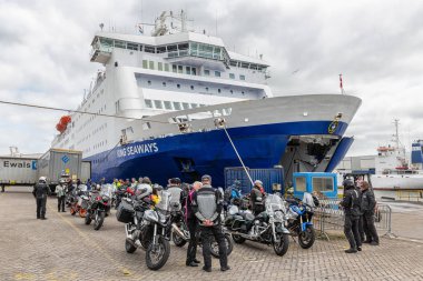 Ferry in Dutch harbor IJmuiden with motorcyclists waiting to embark. clipart