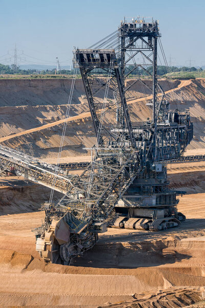 Brown coal open pit landscape with digging excavator in Germany