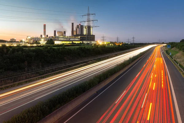 Lange blootstelling zonsondergang over de Duitse snelweg langs elektriciteitscentrales, Duitsland — Stockfoto