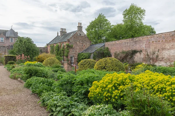 English courtyard with stone wall, furniture and flowers — Stock Photo, Image