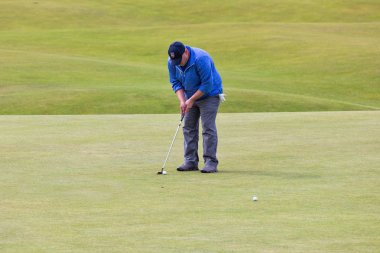 Bir top ünlü golf sahasında Standrews, İskoçya koyarak adam