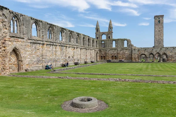 Ruin of Scottish medieval cathedral with tower and resting people — Stock Photo, Image