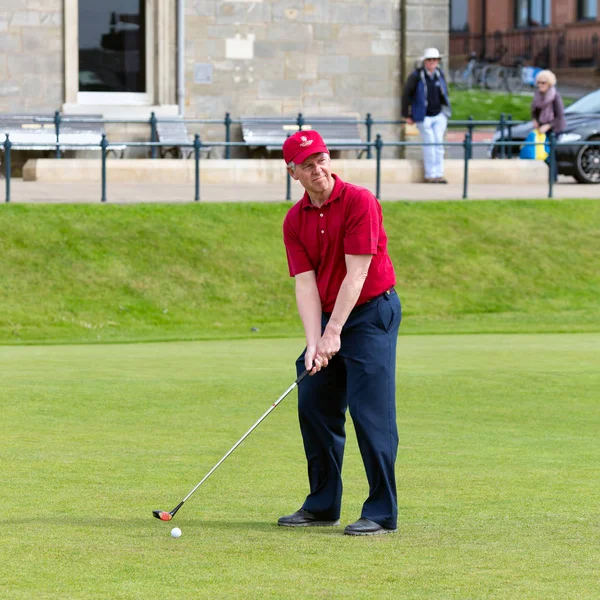 Мужчина играет в гольф на знаменитом поле для гольфа Сент-Эндрюс, Шотландия — стоковое фото