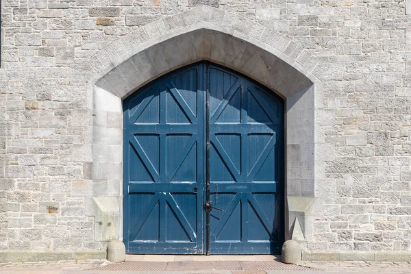 Medieval stone wall with wooden doors of gateway — Stock Photo, Image