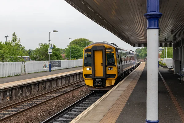 Landelijke treinstation met platform en trein te wachten voor vertrek — Stockfoto