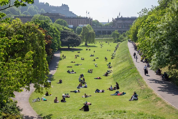 Princes Street Gardens with people sitting in the grass, Edinburgh — Stock Photo, Image