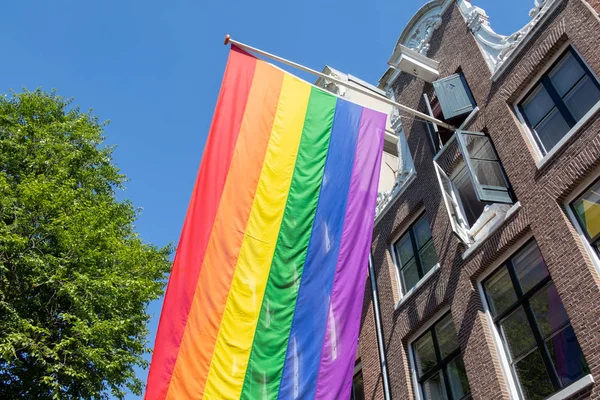 Rainbow flag LGBT la comunidad en el edificio en Amsterdam, Países Bajos — Foto de Stock