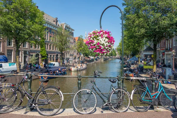 Bro över kanalen med cyklar och blommor, Amsterdam, Nethelands — Stockfoto