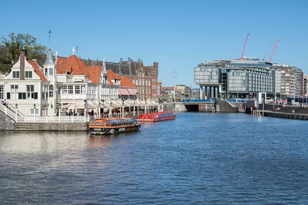 Amsterdam canais com lançamentos e edifícios perto da estação ferroviária central — Fotografia de Stock