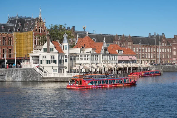 Amsterdams kanaler med lanseringar och byggnader nära centralstation — Stockfoto