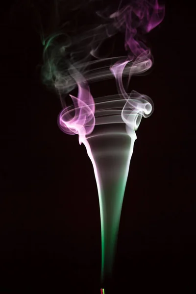 Bunter Rauch von Räucherstäbchen isoliert auf schwarzem Hintergrund — Stockfoto