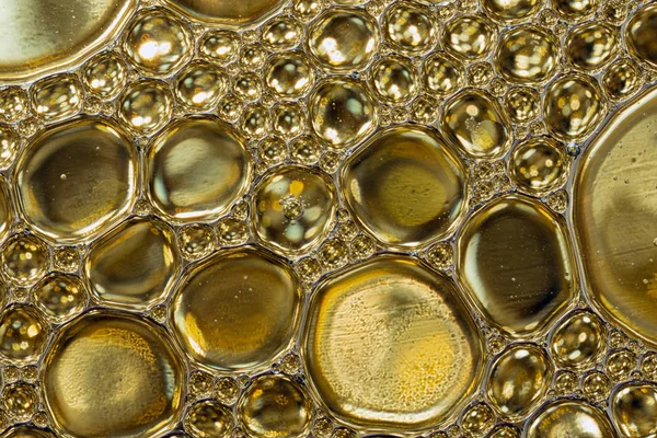 Abstract background of gold colored oil drops on water — Stock Photo, Image