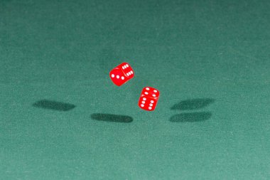 Yeşil bir masanın üzerine düşen iki kırmızı dices