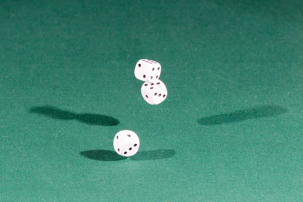 Τρεις λευκοί κύβοι πέφτουν στο πράσινο τραπέζι — Φωτογραφία Αρχείου