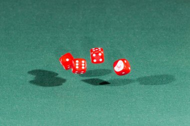 Dört kırmızı dices yeşil bir masanın üzerine düşüyor