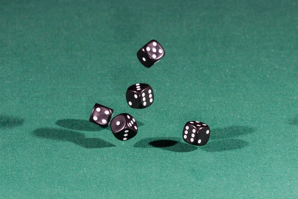 Five black dices falling on a green table — Stock Photo, Image