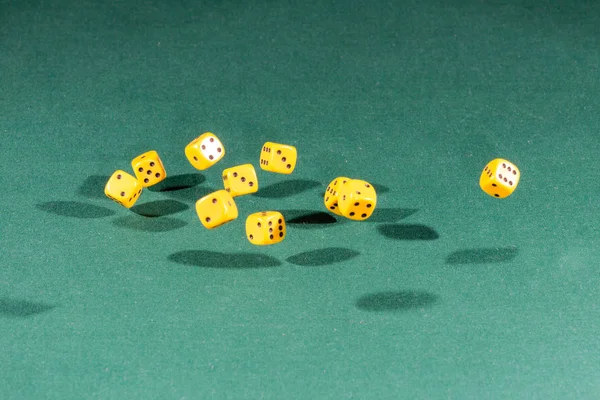 Δέκα κίτρινα ζάρια που υπάγονται σε ένα πράσινο τραπέζι — Φωτογραφία Αρχείου