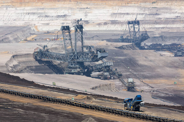 Brown coal open pit landscape with digging excavator in Germany