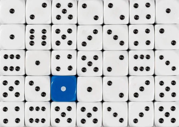 Bakgrund av slumpvis beställda vita tärningar med en blå kub — Stockfoto