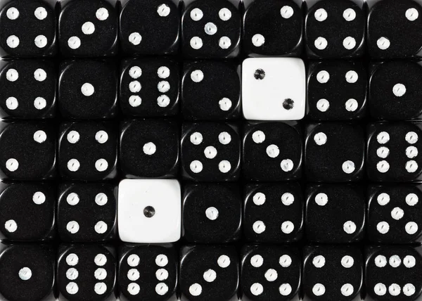 Sfondo di dadi neri ordinati casualmente con due cubi bianchi — Foto Stock
