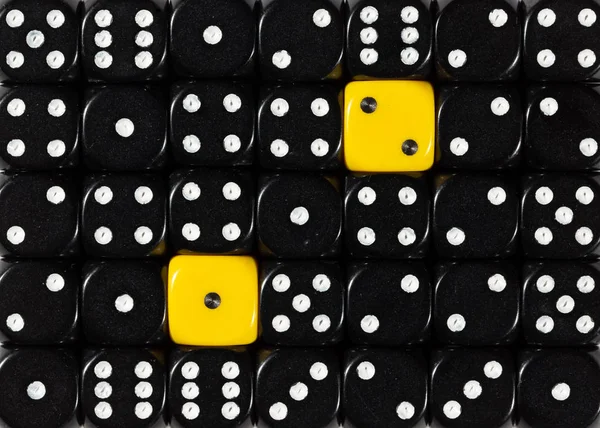 Background of random ordered black dices with two yellow cubes — Stock Photo, Image