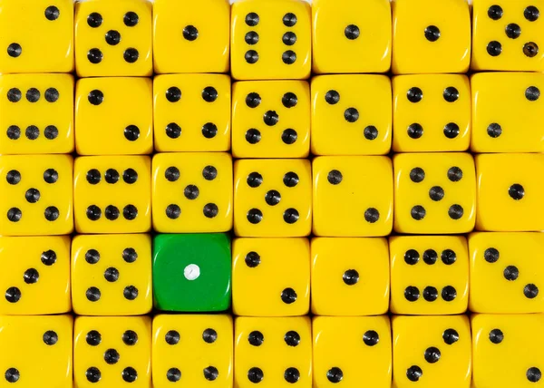 Background of random ordered yellow dices with one green cube — Stock Photo, Image