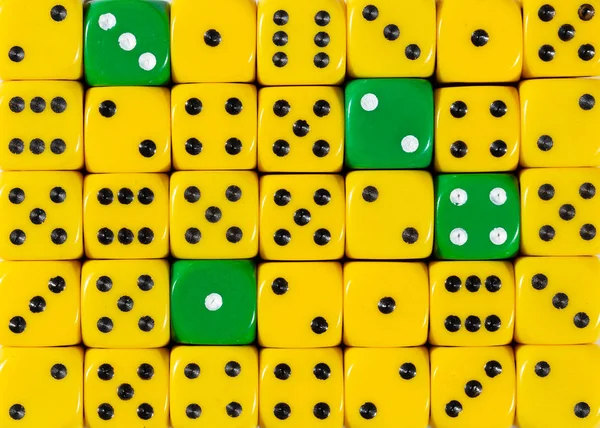 Background of random ordered yellow dices with four green cubes — Stock Photo, Image