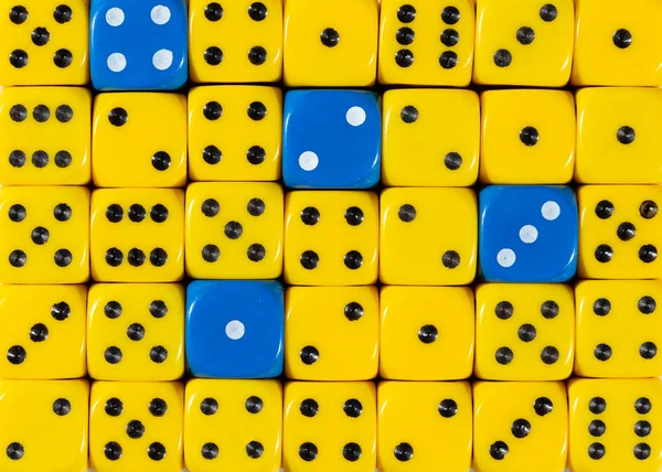 Fond de dés jaunes ordonnés au hasard avec quatre cubes bleus — Photo
