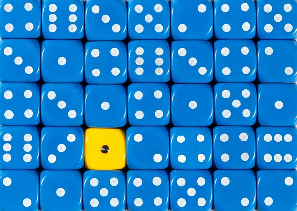 1つの黄色の立方体を持つランダムに順序付けられた青のサイコロの背景 — ストック写真