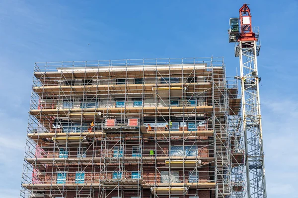 Budowa nowego budynku apartamentowego z rusztowań i Mason pracowników — Zdjęcie stockowe