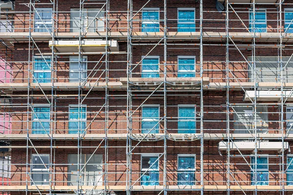 Cantiere nuovo condominio con ponteggi e muratori — Foto Stock