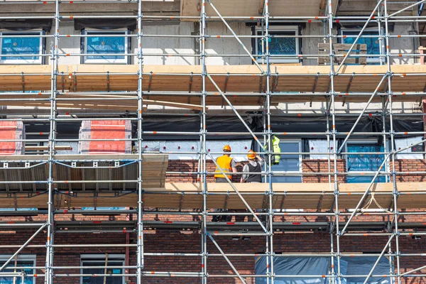 Chantier de construction immeuble neuf avec échafaudage et maçon travailleurs — Photo