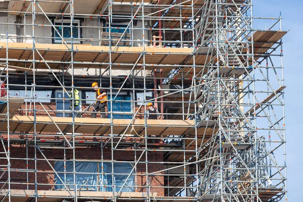 Chantier de construction immeuble neuf avec échafaudage et maçon travailleurs — Photo