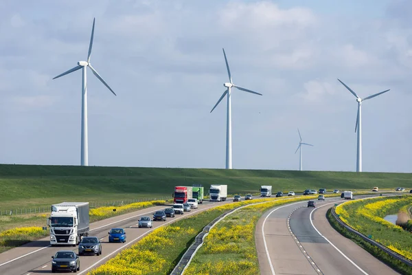 Auto-estrada holandesa perto de Lelystad com turbinas eólicas e colza em flor — Fotografia de Stock