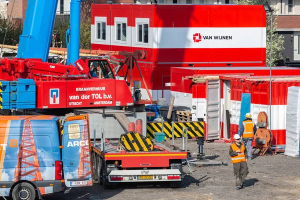 Construction site with mobile crane, storage containers and crew wagons — Stock Photo, Image