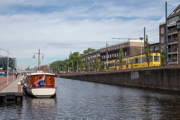 Cityscape Delft con canal y tranvía de paso a la estación de tren — Foto de Stock