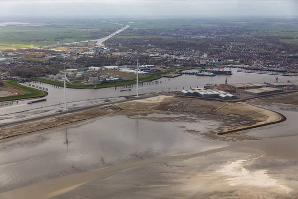 Flysikt til nederlandsk havn Delfzijl med vindmøller og fabrikker – stockfoto