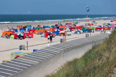 Sahilde dinlendirici sahil ziyaretçileri ile Hollandalı sahil
