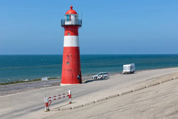 Lighthouse at dike with recreating people near Westkapelle, the Netherlands — Stock Photo, Image