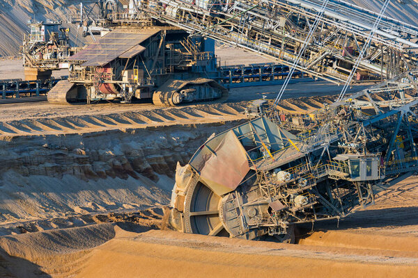 Brown coal open pit landscape with digging excavators in Germany
