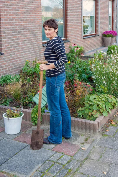 Woman gardening in the front garden of her house — Stock Photo, Image