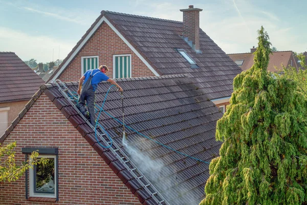 Cleaner with pressure washer at roof house cleaning roof tiles — Stock Photo, Image