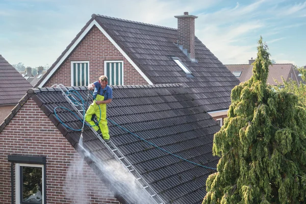 Nettoyant avec laveuse sous pression au toit de la maison nettoyage des tuiles — Photo